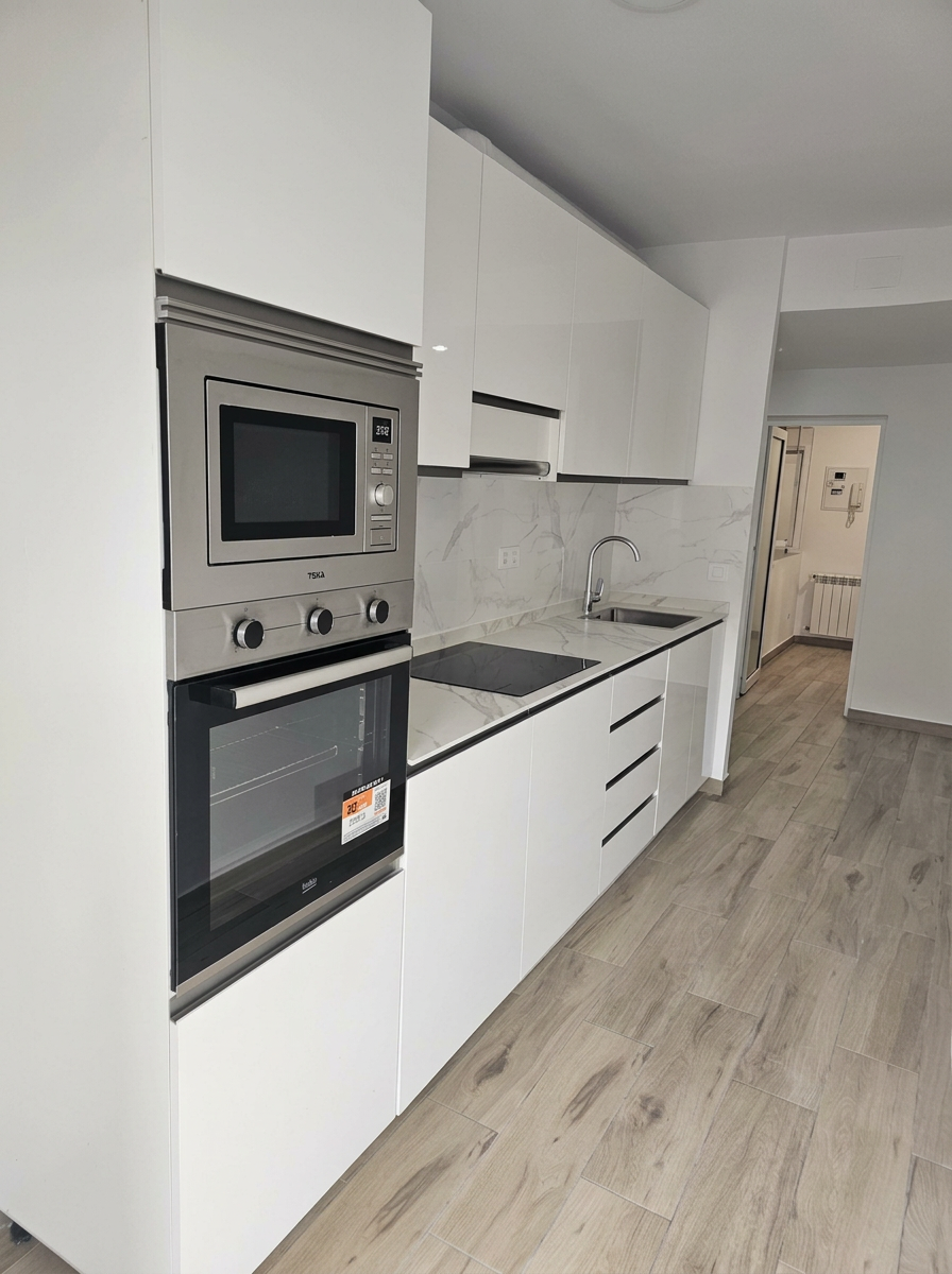 Cocina lineal blanca con electrodomésticos integrados