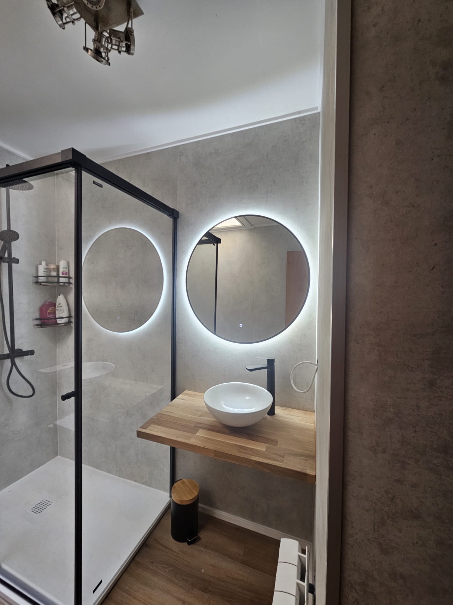 Cocina abierta con muebles blancos y suelo de madera