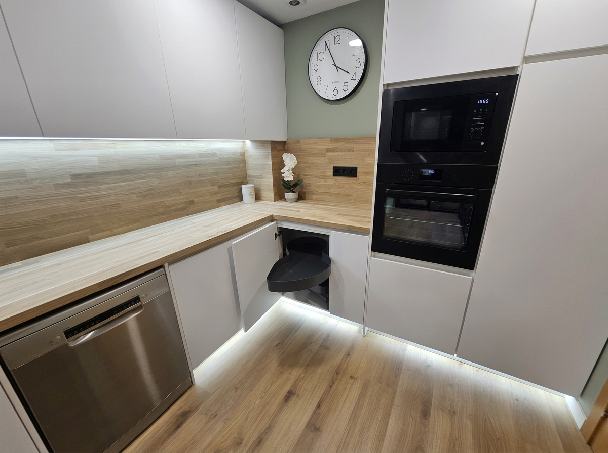 Cocina blanca en esquina con encimera de madera e iluminación LED