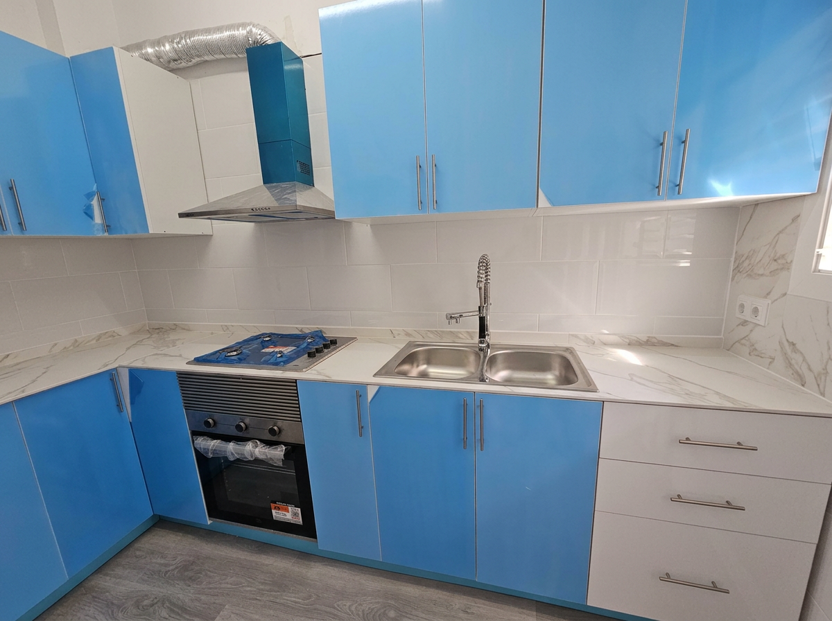 Cocina azul y blanca con encimera efecto mármol